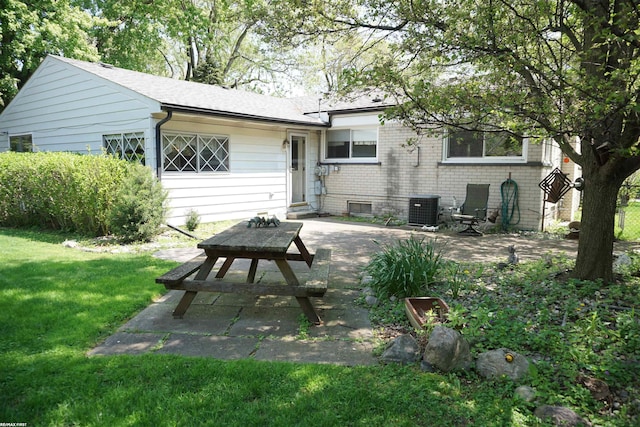 rear view of house with a patio area, a yard, and central AC
