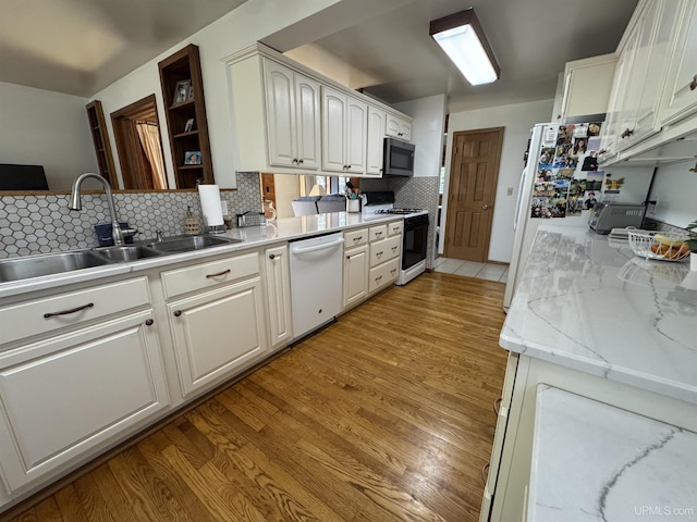 102 Forest Dr, Norway, MI 49870 - kitchen with white appliances, a sink, tasteful backsplash, white cabinets, and light wood-style floors
