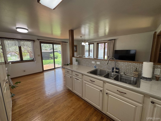 102 Forest Dr, Norway, MI 49870 - kitchen with a sink, decorative backsplash, white cabinetry, light countertops, and light wood finished floors