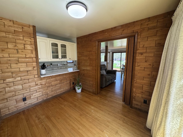 102 Forest Dr, Norway, MI 49870 - kitchen with light wood finished floors, glass insert cabinets, white cabinetry, light countertops, and wood walls