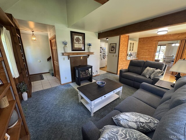 102 Forest Dr, Norway, MI 49870 - living room featuring a chandelier, light colored carpet, baseboards, beamed ceiling, and a wood stove