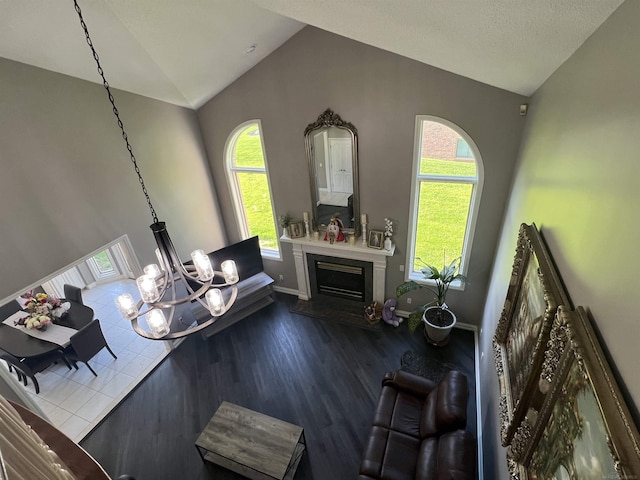 53641 Buckingham Ln, Shelby Twp, MI 48316 - living area featuring vaulted ceiling, dark wood-type flooring, a fireplace, baseboards, and a chandelier