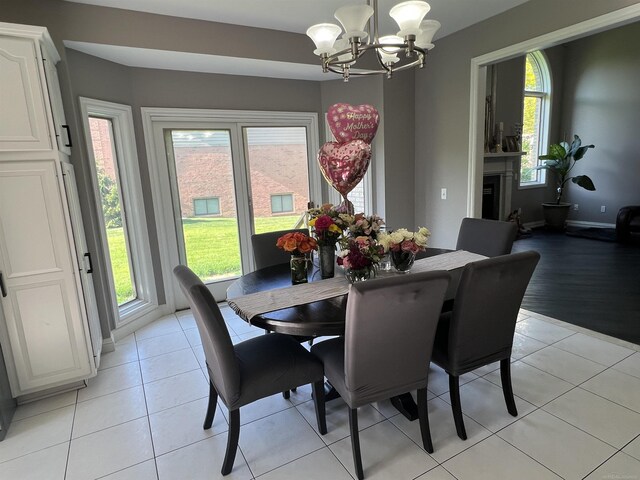 53641 Buckingham Ln, Shelby Twp, MI 48316 - dining area featuring a chandelier, light tile patterned floors, a fireplace, and baseboards
