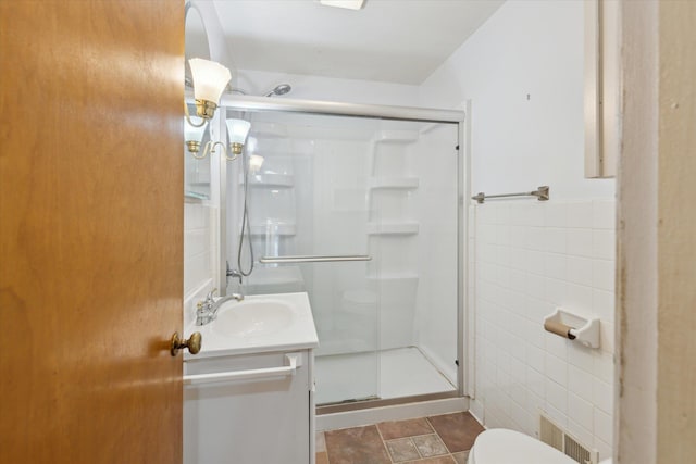 402 E Fisher St, Bay City, MI 48706 - bathroom with tile walls, a stall shower, toilet, and vanity