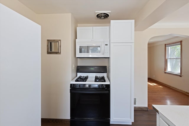 402 E Fisher St, Bay City, MI 48706 - kitchen featuring white microwave, gas range oven, white cabinets, and arched walkways