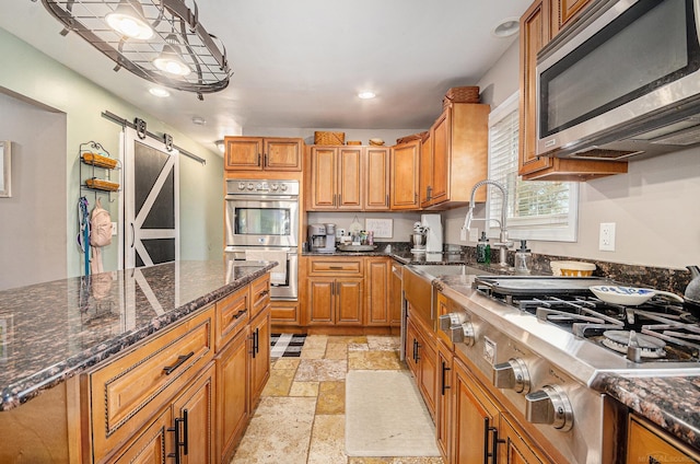38186 Jefferson Ave, Harrison Twp, MI 48045 - kitchen featuring stainless steel appliances, stone tile flooring, a barn door, brown cabinetry, and recessed lighting