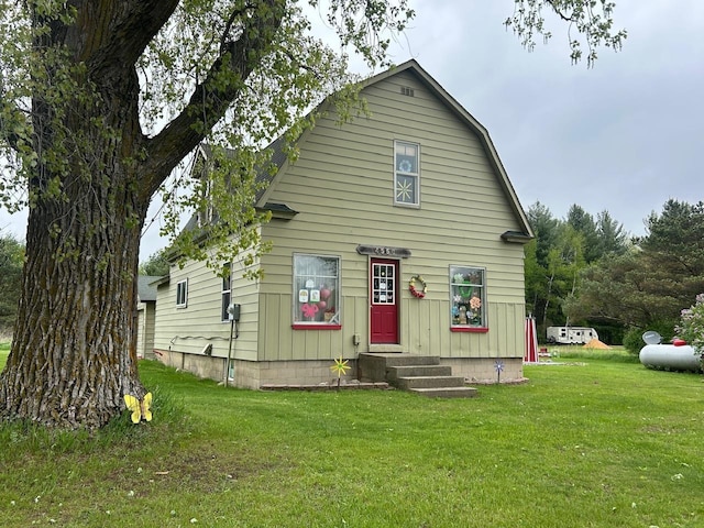 4550 Calhoun Rd, Beaverton, MI 48612 - view of front of house with a front lawn, entry steps, and a gambrel roof