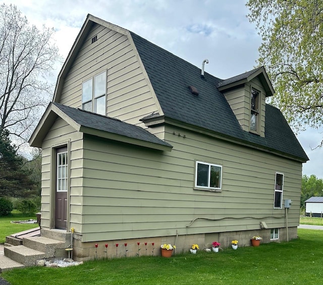 4550 Calhoun Rd, Beaverton, MI 48612 - view of side of home with a shingled roof, a yard, a gambrel roof, and entry steps
