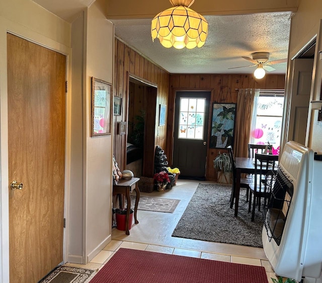 4550 Calhoun Rd, Beaverton, MI 48612 - entryway featuring wooden walls, light tile patterned flooring, and a ceiling fan