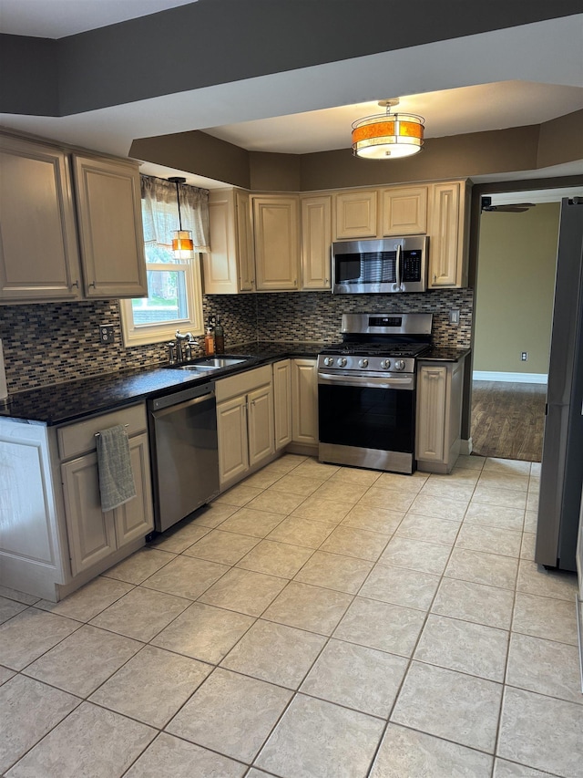 4283 Snoal Ln, Shelby Twp, MI 48316 - kitchen featuring appliances with stainless steel finishes, a sink, dark countertops, decorative backsplash, and light tile patterned floors