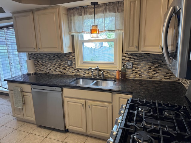 4283 Snoal Ln, Shelby Twp, MI 48316 - kitchen with appliances with stainless steel finishes, a sink, tasteful backsplash, light tile patterned floors, and dark stone countertops