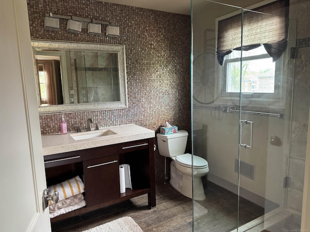 4283 Snoal Ln, Shelby Twp, MI 48316 - full bathroom with a shower stall, toilet, vanity, tile walls, and wood finished floors