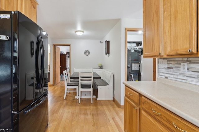 1497 Parke St, Rochester Hills, MI 48307 - kitchen with freestanding refrigerator, backsplash, light wood finished floors, light countertops, and baseboards