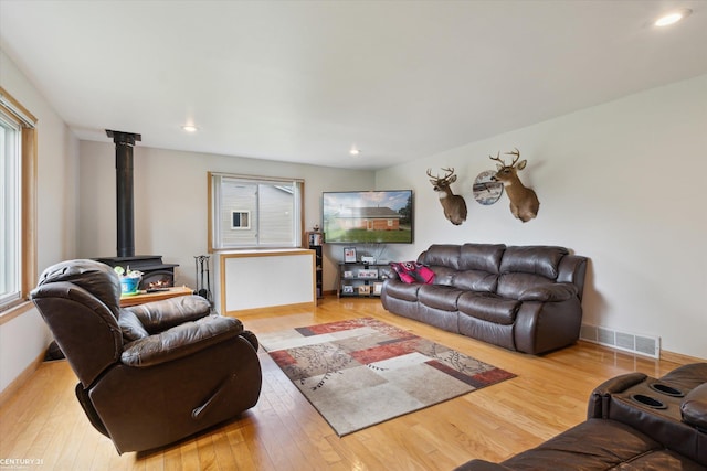 1497 Parke St, Rochester Hills, MI 48307 - living room featuring healthy amount of natural light, a wood stove, wood finished floors, and recessed lighting