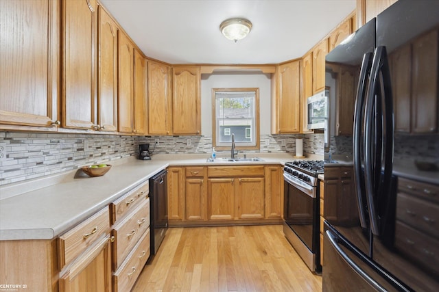 1497 Parke St, Rochester Hills, MI 48307 - kitchen with black appliances, a sink, decorative backsplash, light wood-style floors, and light countertops