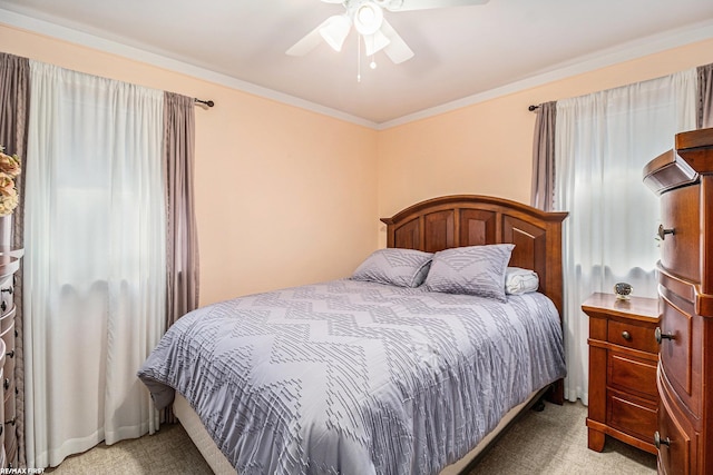 bedroom with light colored carpet, ornamental molding, and ceiling fan