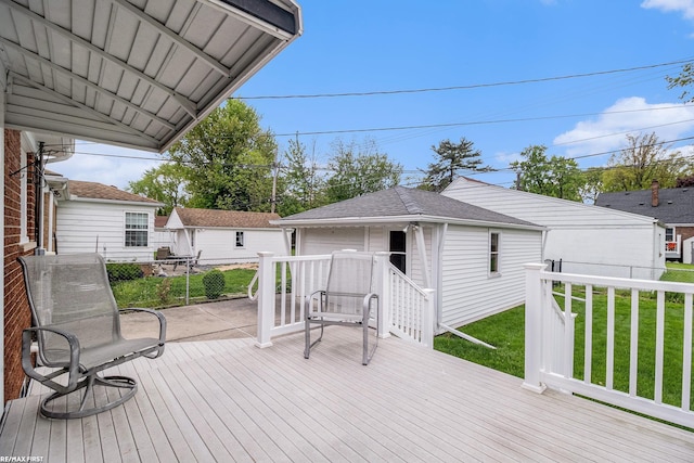 wooden deck with a yard and an outdoor structure