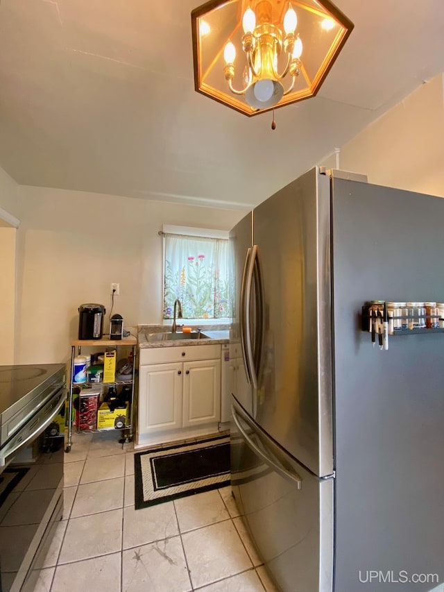 213 N Fifth St, Marquette, MI 49855 - kitchen featuring stainless steel appliances, a sink, white cabinetry, a chandelier, and light tile patterned floors