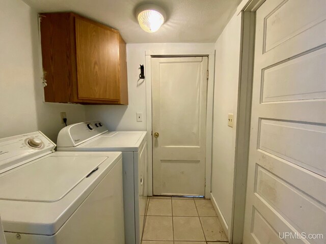 213 N Fifth St, Marquette, MI 49855 - clothes washing area with cabinet space, washing machine and dryer, and light tile patterned floors