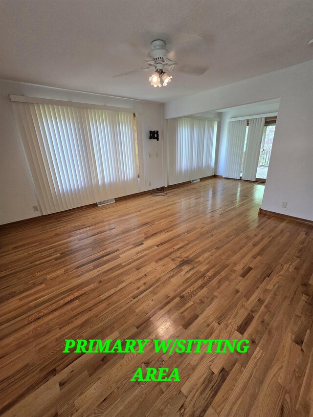 41 W River Dr, Gladwin, MI 48624 - unfurnished living room featuring wood finished floors, a ceiling fan, and baseboards