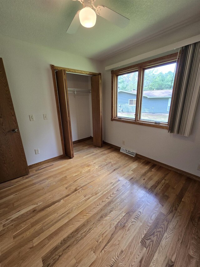 41 W River Dr, Gladwin, MI 48624 - unfurnished bedroom with a closet, light wood-style floors, ceiling fan, and a textured ceiling