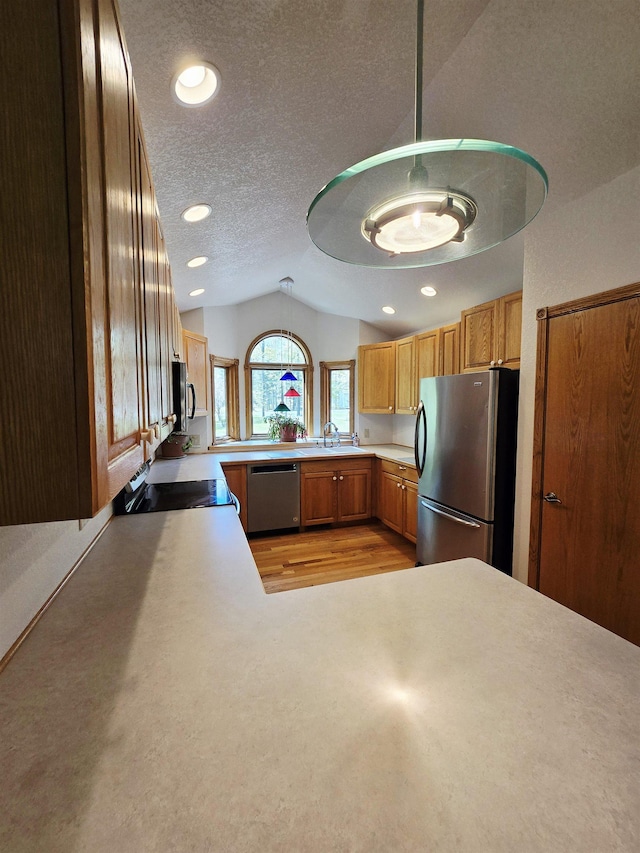 41 W River Dr, Gladwin, MI 48624 - kitchen with appliances with stainless steel finishes, vaulted ceiling, a sink, a textured ceiling, and light countertops