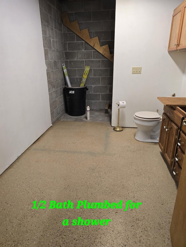 41 W River Dr, Gladwin, MI 48624 - bathroom with speckled floor, toilet, vanity, and carpet flooring