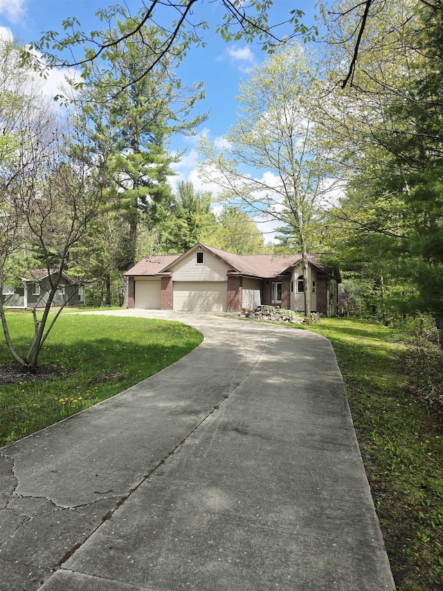 41 W River Dr, Gladwin, MI 48624 - view of front facade with concrete driveway, a front lawn, brick siding, and a garage