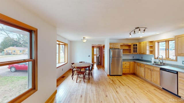 730 Elliott Ave, Ishpeming, MI 49855 - kitchen featuring stainless steel appliances, a sink, open shelves, light wood-style flooring, and healthy amount of natural light