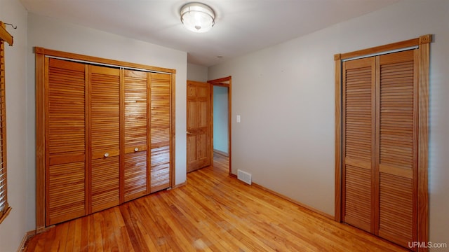 730 Elliott Ave, Ishpeming, MI 49855 - unfurnished bedroom featuring light wood-style flooring, baseboards, and a closet