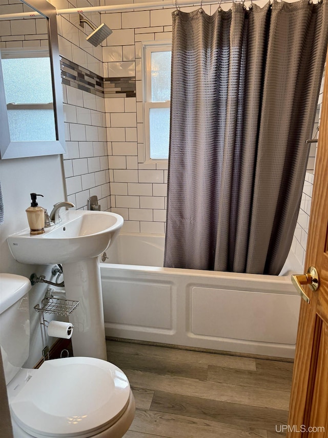 730 Elliott Ave, Ishpeming, MI 49855 - bathroom featuring shower / tub combo, toilet, and wood finished floors