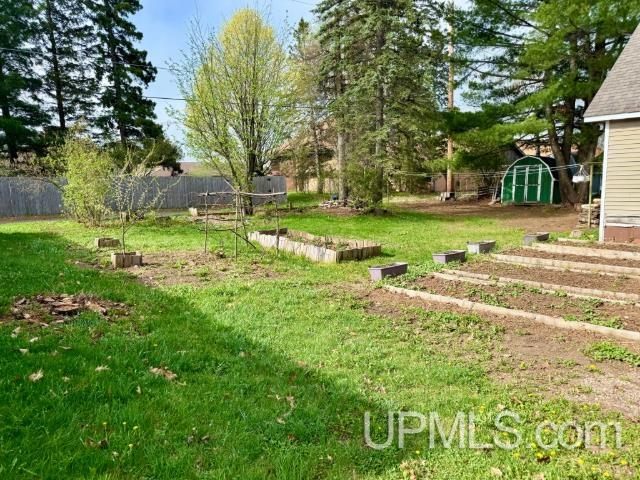 730 Elliott Ave, Ishpeming, MI 49855 - view of yard with a shed, a vegetable garden, and an outbuilding