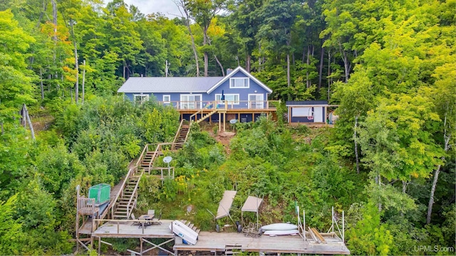 106 Green Rd, Michigamme, MI 49861 - rear view of house with stairs, a wooded view, metal roof, and a wooden deck