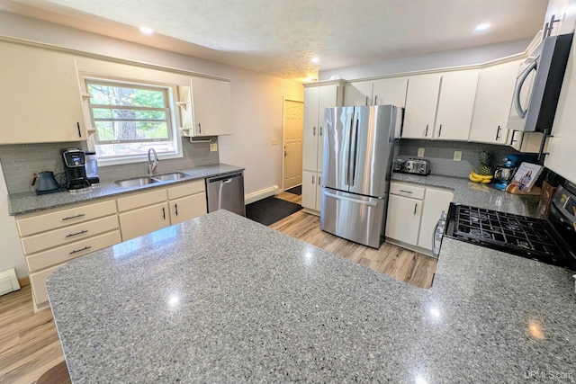 14 Arrowhead Dr, Marquette, MI 49855 - kitchen featuring appliances with stainless steel finishes, a sink, backsplash, light wood-style floors, and recessed lighting