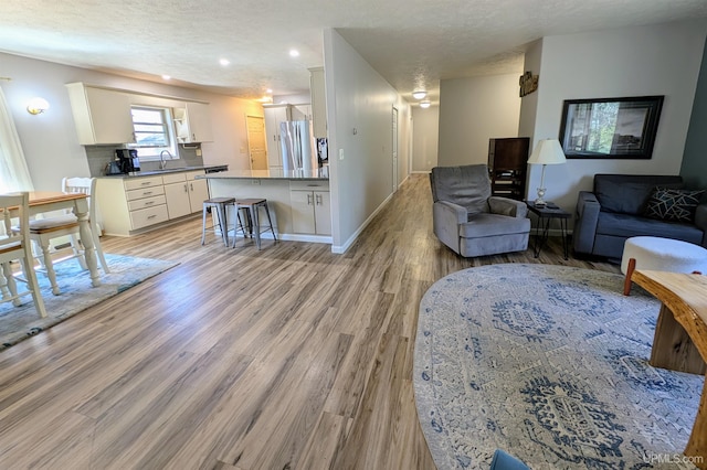 14 Arrowhead Dr, Marquette, MI 49855 - living room with a textured ceiling, light wood-style floors, baseboards, and recessed lighting