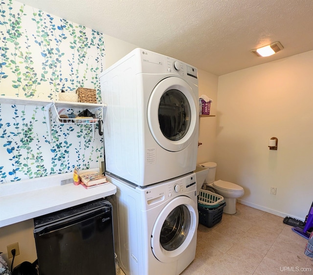 14 Arrowhead Dr, Marquette, MI 49855 - laundry room featuring stacked washer and clothes dryer, a textured ceiling, baseboards, and light tile patterned floors
