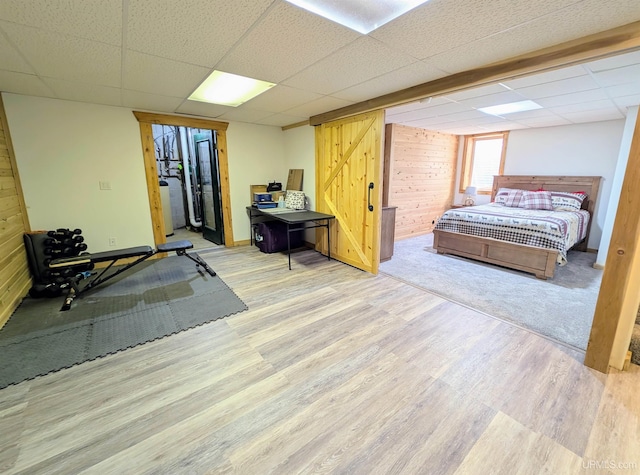 14 Arrowhead Dr, Marquette, MI 49855 - bedroom with a drop ceiling, wood finished floors, wooden walls, and baseboards