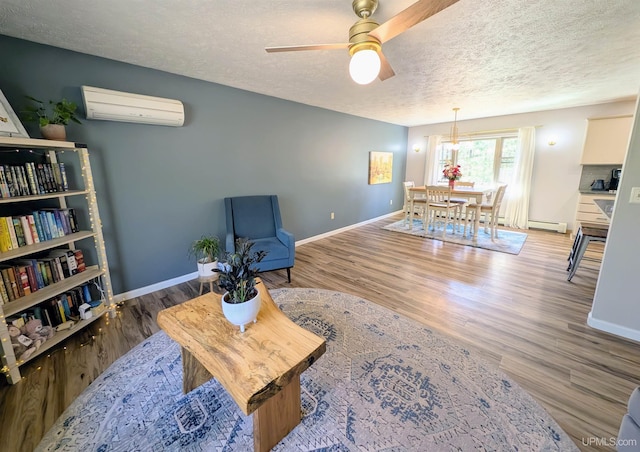 14 Arrowhead Dr, Marquette, MI 49855 - living area featuring a wall unit AC, a ceiling fan, a textured ceiling, baseboards, and wood finished floors