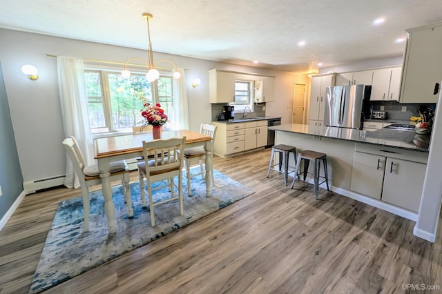 14 Arrowhead Dr, Marquette, MI 49855 - dining area featuring light wood finished floors, a chandelier, recessed lighting, baseboards, and a baseboard heating unit