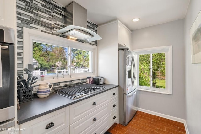 1131 Boyd St, Troy, MI 48083 - kitchen with stainless steel appliances, wall chimney range hood, dark countertops, baseboards, and plenty of natural light