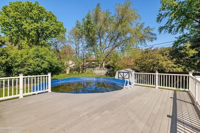 1131 Boyd St, Troy, MI 48083 - view of pool with a deck, a storage shed, an outbuilding, and fence