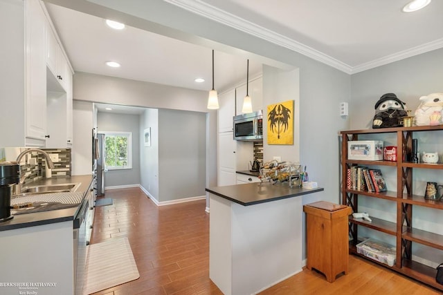 1131 Boyd St, Troy, MI 48083 - kitchen featuring stainless steel appliances, dark countertops, white cabinetry, wood finished floors, and ornamental molding