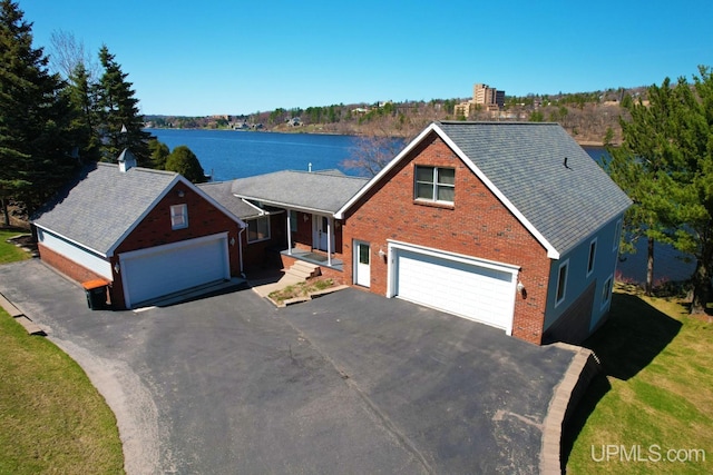 18918 Canal Rd, Houghton, MI 49931 - traditional-style house with brick siding, a water view, driveway, and roof with shingles