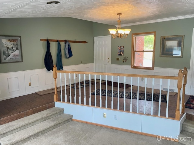 18918 Canal Rd, Houghton, MI 49931 - staircase with an ornate ceiling, a chandelier, wainscoting, and carpet
