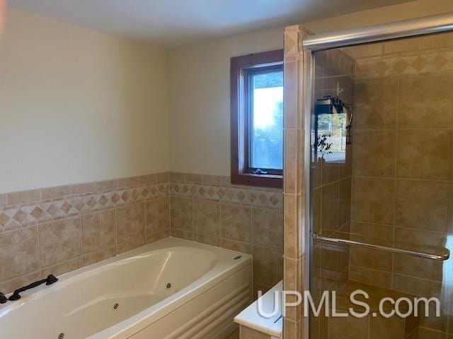 18918 Canal Rd, Houghton, MI 49931 - bathroom featuring a stall shower, a tub with jets, and tile walls