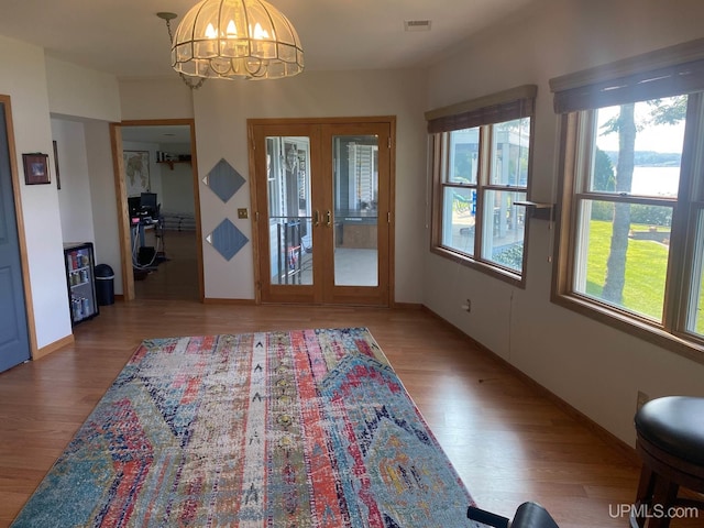 18918 Canal Rd, Houghton, MI 49931 - foyer entrance with french doors, wood finished floors, a chandelier, and baseboards