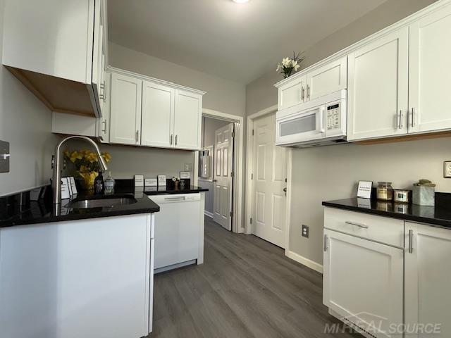 1416 Kearney St, Port Huron, MI 48060 - kitchen featuring white appliances, dark countertops, dark wood-type flooring, and white cabinetry