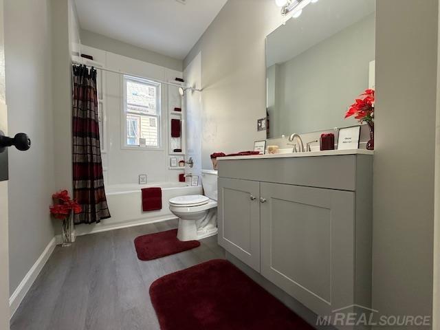 1416 Kearney St, Port Huron, MI 48060 - full bath with wood finished floors, toilet, shower / bathtub combination with curtain, and vanity