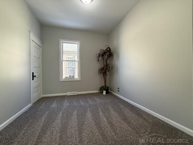 1416 Kearney St, Port Huron, MI 48060 - spare room featuring dark colored carpet and baseboards