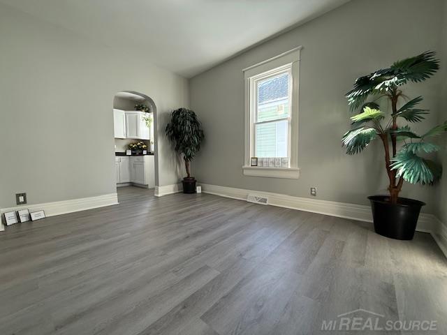 1416 Kearney St, Port Huron, MI 48060 - empty room featuring dark wood-style floors, baseboards, and arched walkways